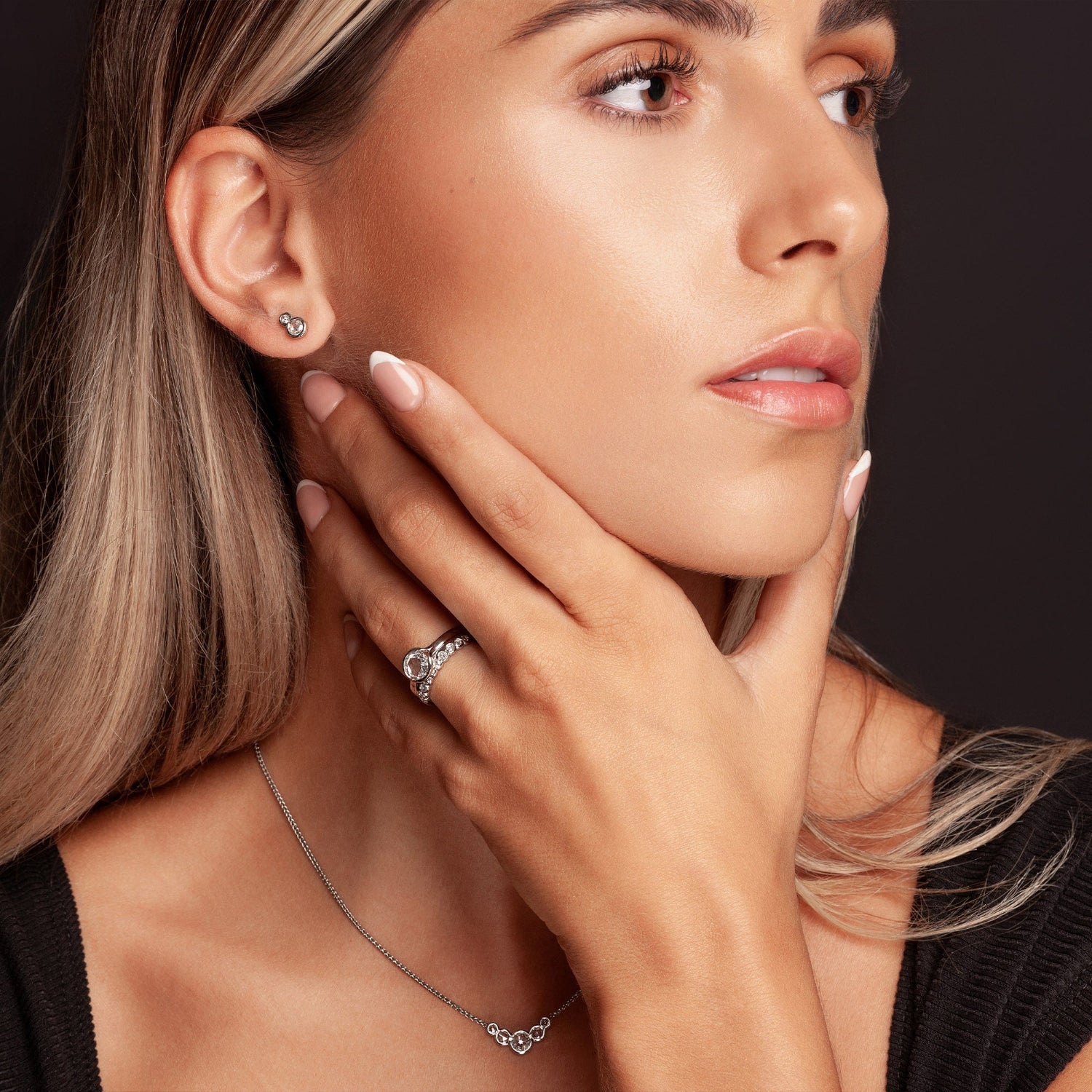 Model wearing rose cut diamond earrings, necklace and engagement and wedding rings