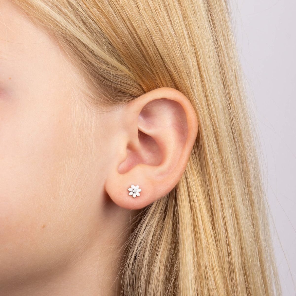 Children's Diamond Daisy Earrings with White Enamel Petals on Model's ear.